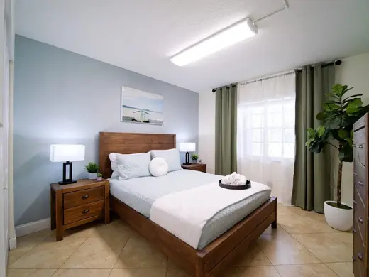 Cozy bedroom with wooden furniture at The Recovery Team - Delray Beach, a detox center in Miami.